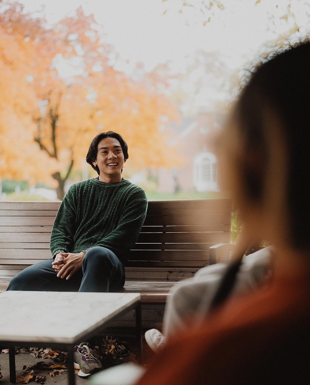 Students talk together on the porch of a campus residence.