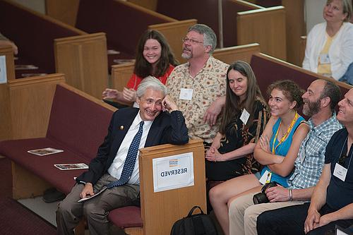 The Alumni Assembly audience, including President Bierman at right, reacts to alumni stories shar...